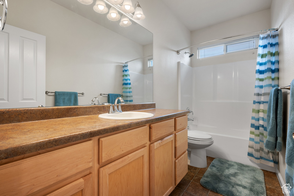 Bathroom featuring tile patterned floors, vanity, toilet, and shower / bath combination with curtain