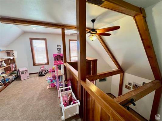 Rec room featuring carpet floors, a ceiling fan, and vaulted ceiling
