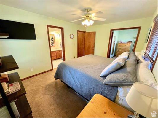 Bedroom with a ceiling fan, baseboards, ensuite bathroom, and carpet