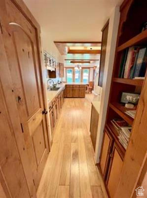 Corridor featuring french doors and light wood-style floors