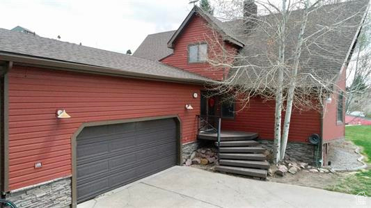 View of home's exterior featuring a garage, driveway, and roof with shingles