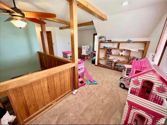 Recreation room featuring carpet floors, ceiling fan, and beamed ceiling