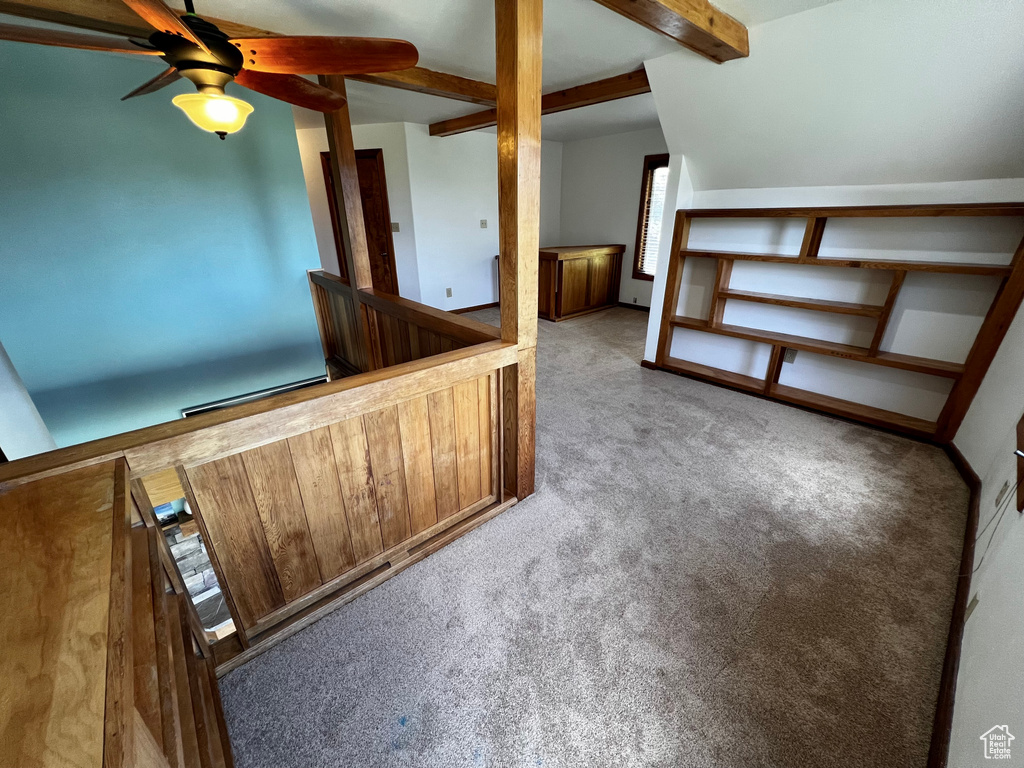 Bonus room featuring carpet floors, beamed ceiling, a ceiling fan, and baseboards