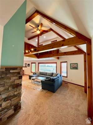Living room featuring carpet flooring, a ceiling fan, and vaulted ceiling with beams