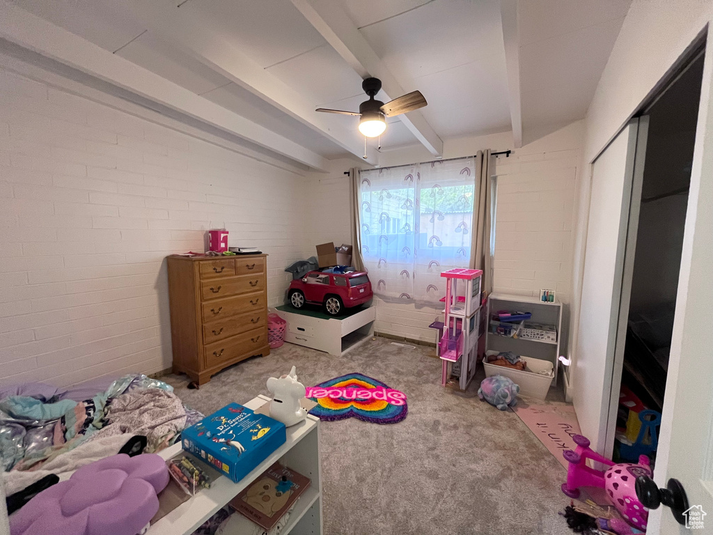 Bedroom featuring ceiling fan, carpet flooring, and beam ceiling