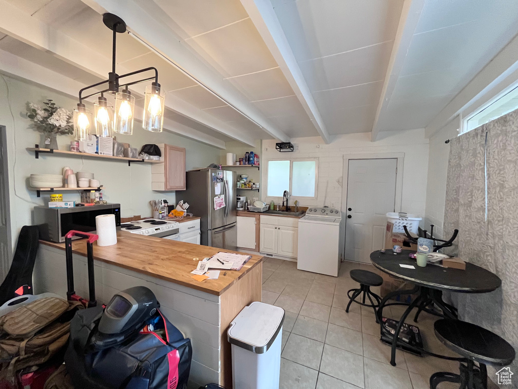 Kitchen with washer / clothes dryer, open shelves, appliances with stainless steel finishes, and plenty of natural light