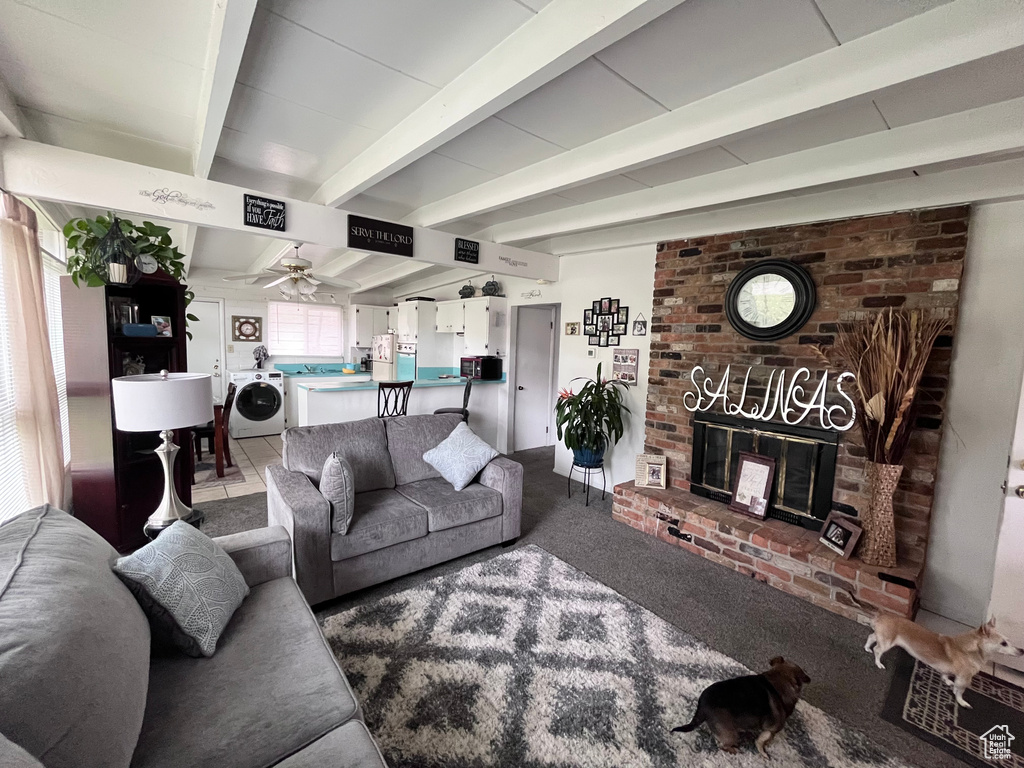 Living area with carpet floors, a ceiling fan, a brick fireplace, and beam ceiling