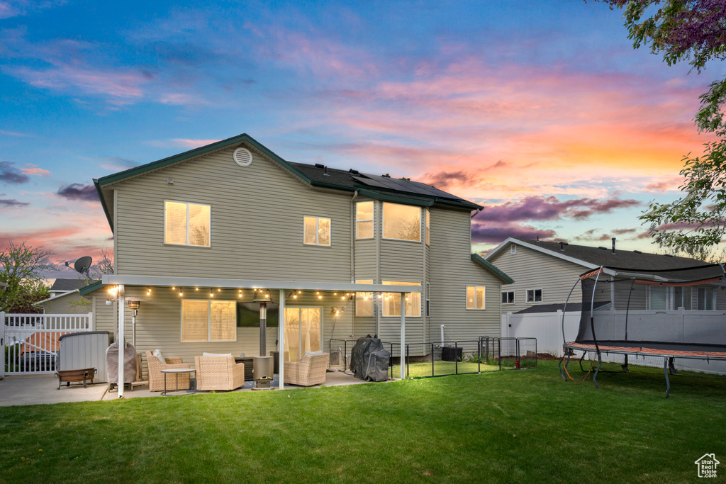 Back of property with a yard, a gate, a patio area, and an outdoor hangout area
