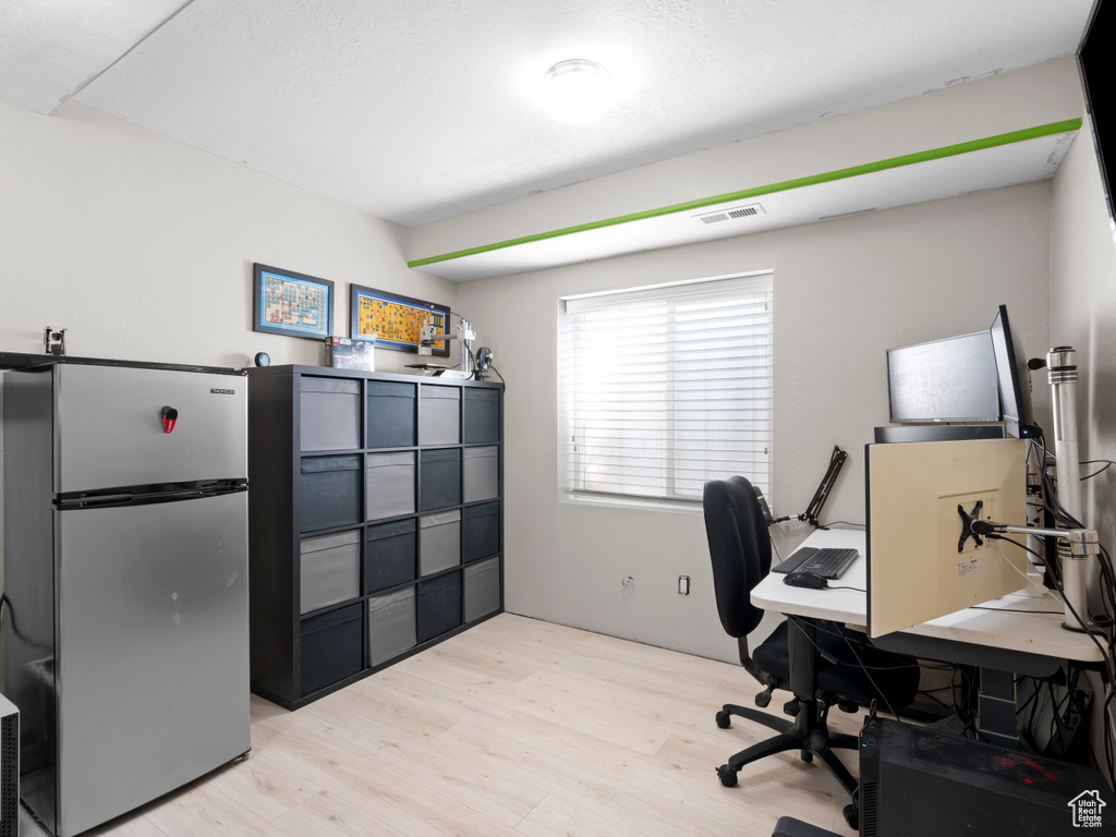 Home office featuring visible vents and light wood finished floors