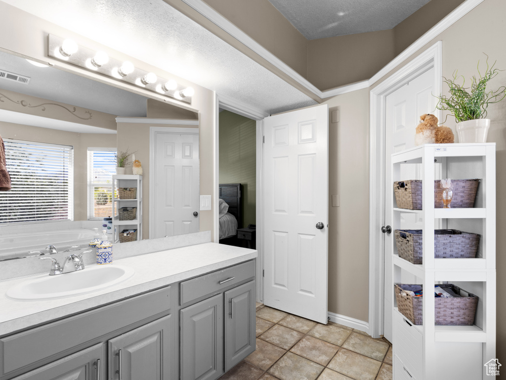 Full bath featuring baseboards, visible vents, a bathtub, and vanity