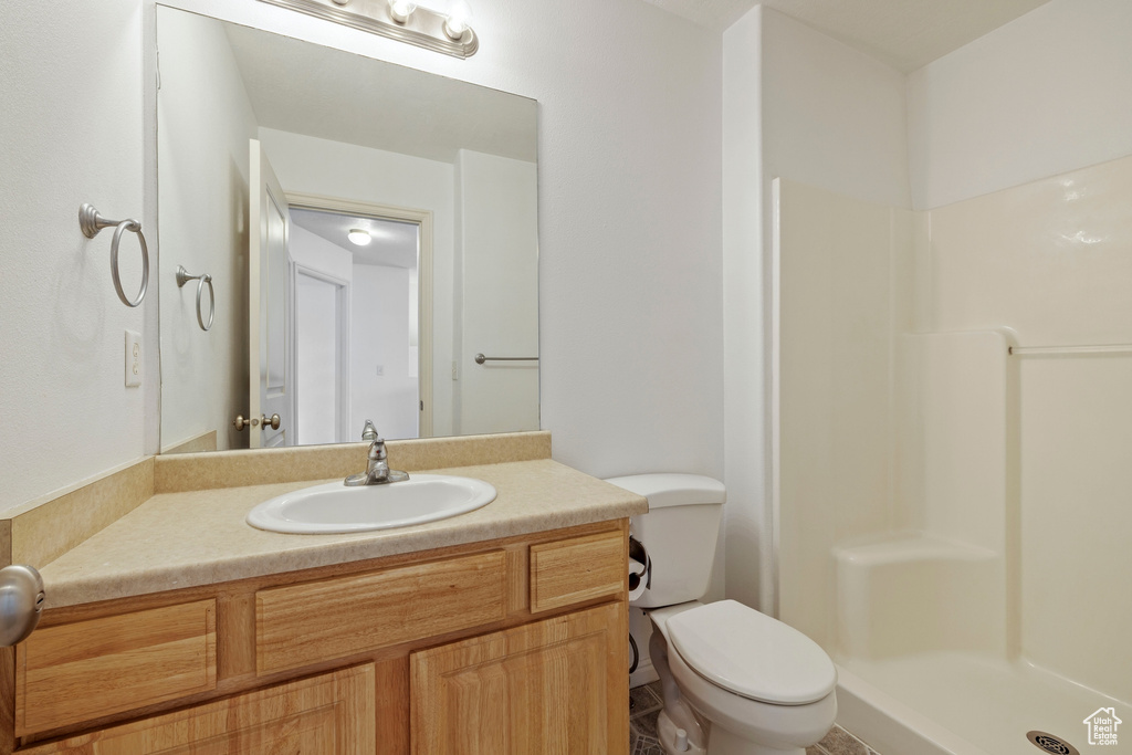 Bathroom with a walk in shower, toilet, and vanity