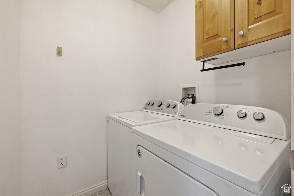 Clothes washing area featuring cabinet space and washing machine and clothes dryer