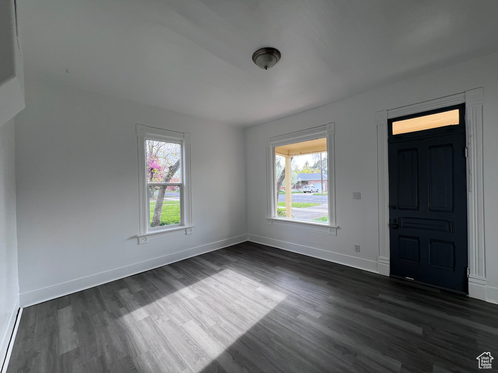 Interior space with baseboards and dark wood finished floors