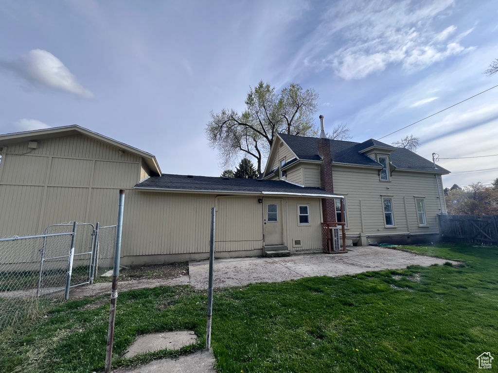 Back of property with fence, central AC, a gate, a patio area, and a lawn