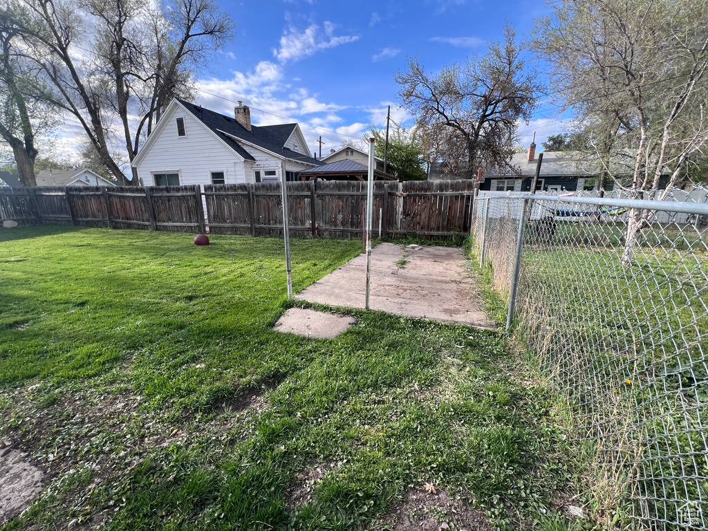 View of yard with a fenced backyard and a patio