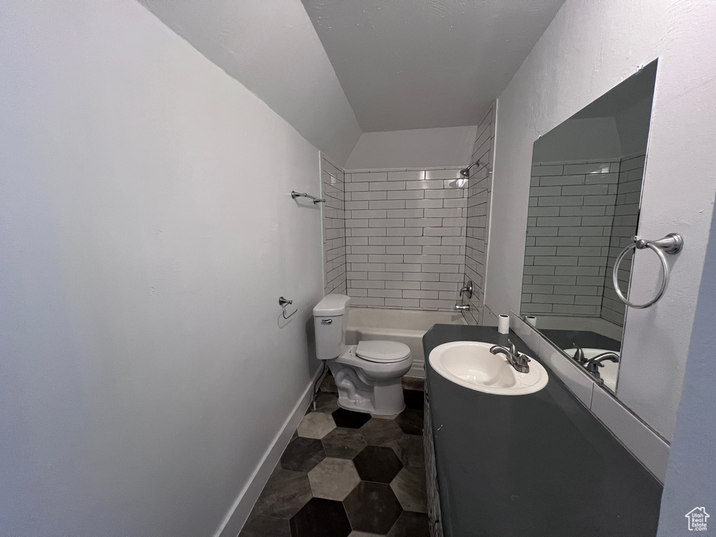 Full bath with vanity, baseboards, washtub / shower combination, and toilet
