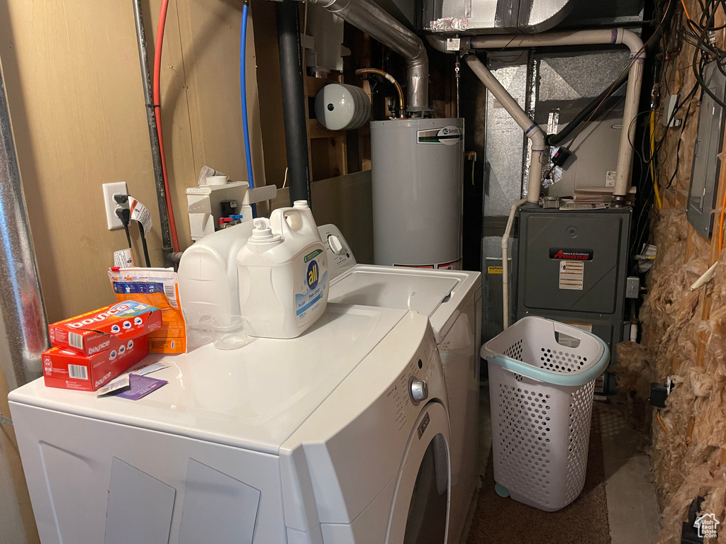 Laundry room featuring laundry area, independent washer and dryer, and water heater
