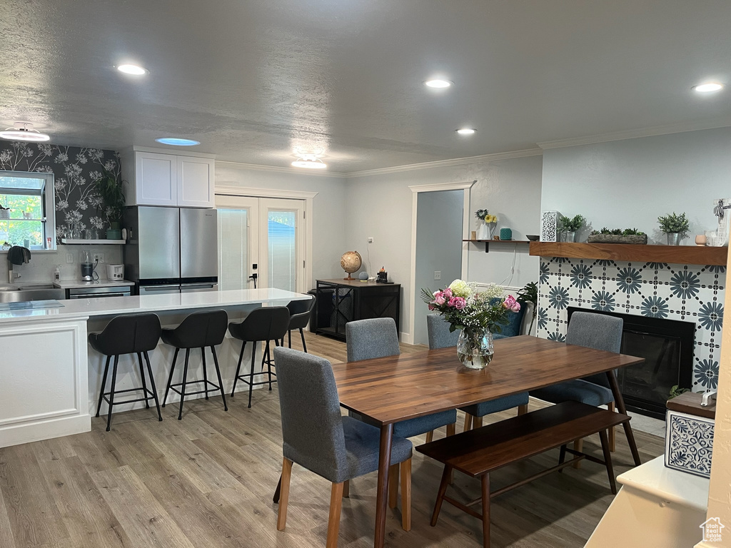 Dining room with recessed lighting, ornamental molding, and light wood-style flooring
