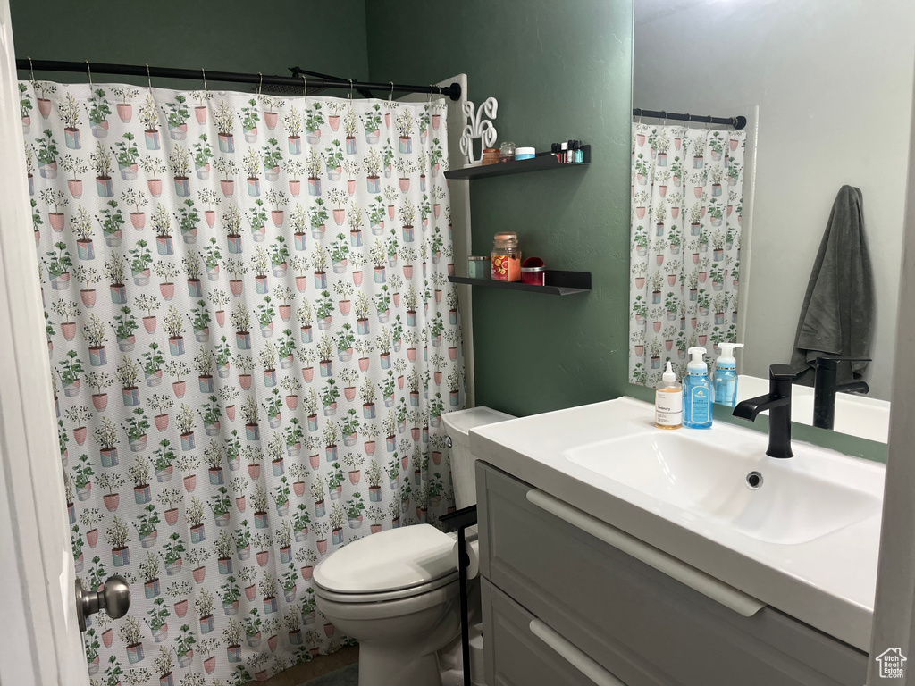 Bathroom with vanity, toilet, and a shower with curtain