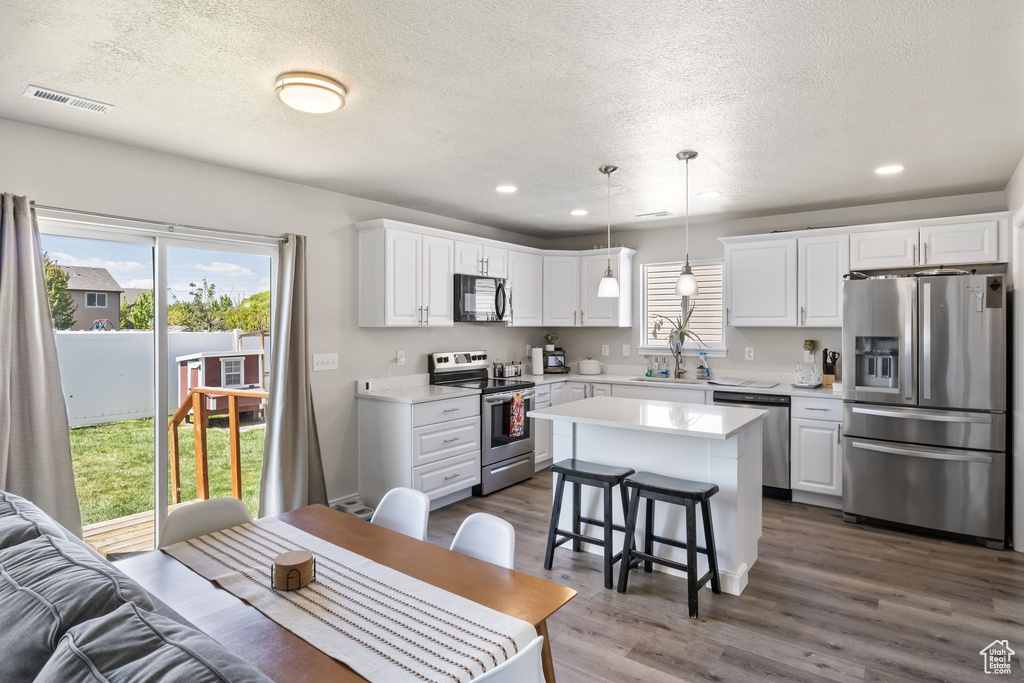 Kitchen with visible vents, light countertops, a textured ceiling, and stainless steel appliances