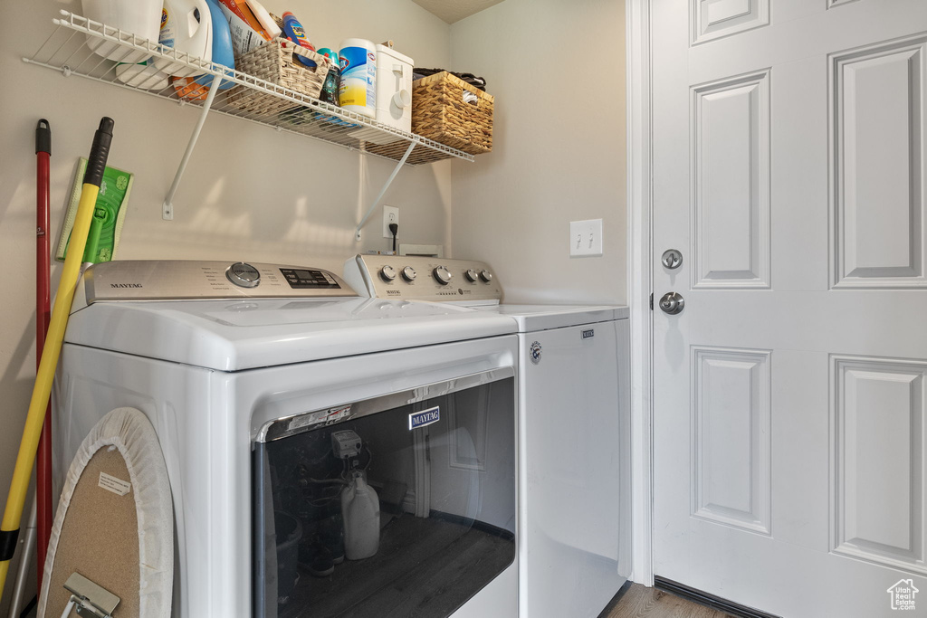 Clothes washing area with laundry area, light wood-style flooring, and washing machine and clothes dryer