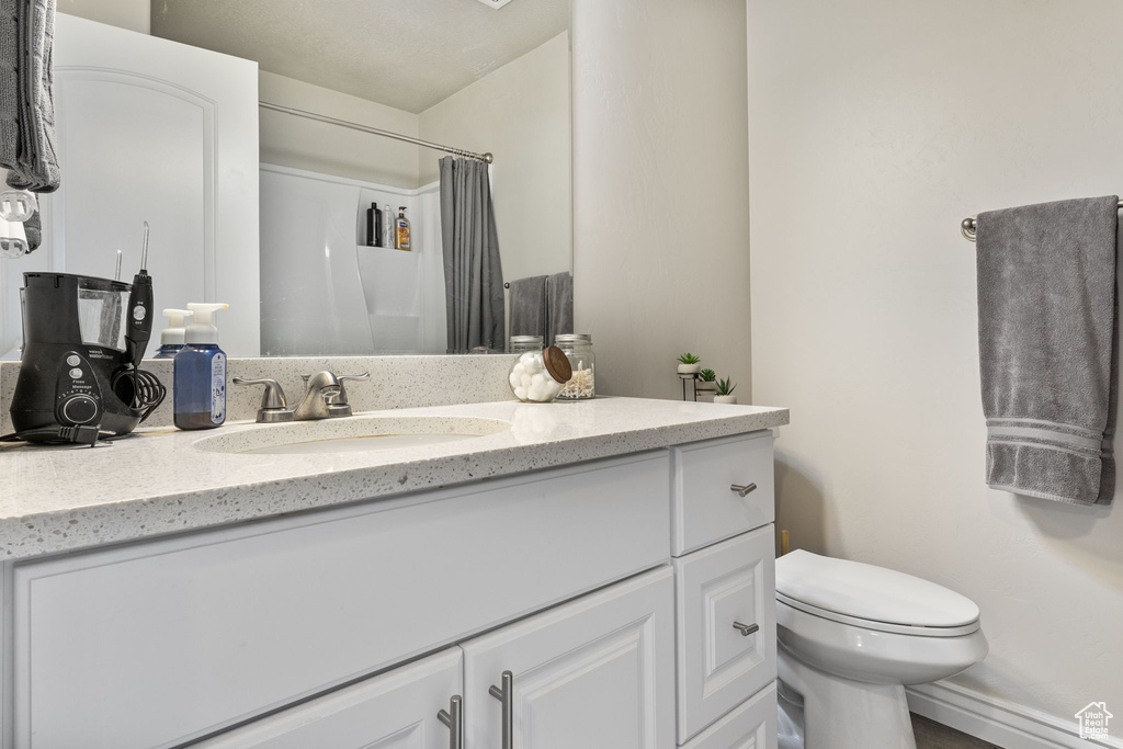 Bathroom featuring vanity, a shower with curtain, and toilet