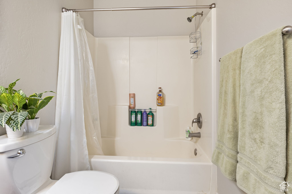 Full bath with shower / bath combo with shower curtain and toilet