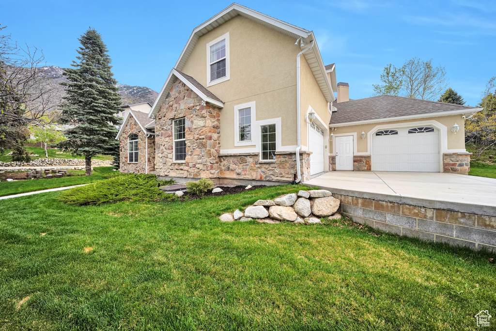 View of front of property featuring stone siding, stucco siding, and a garage