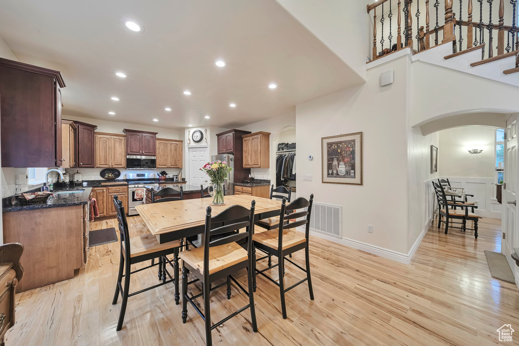 Dining space featuring light wood-style floors, recessed lighting, baseboards, and arched walkways