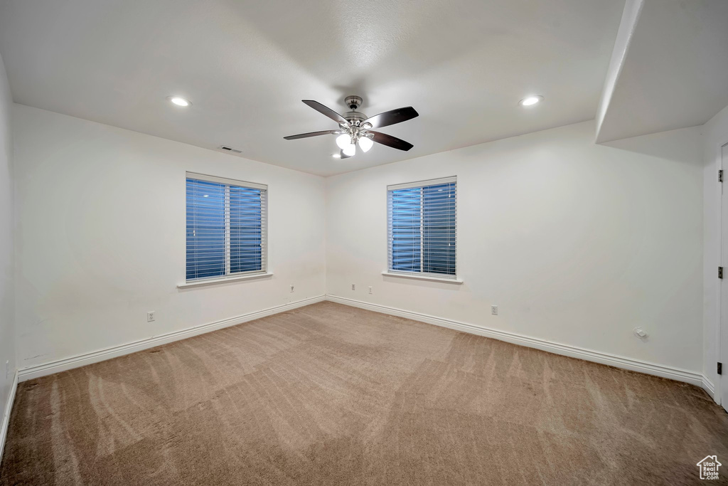 Unfurnished room featuring baseboards, a ceiling fan, and carpet