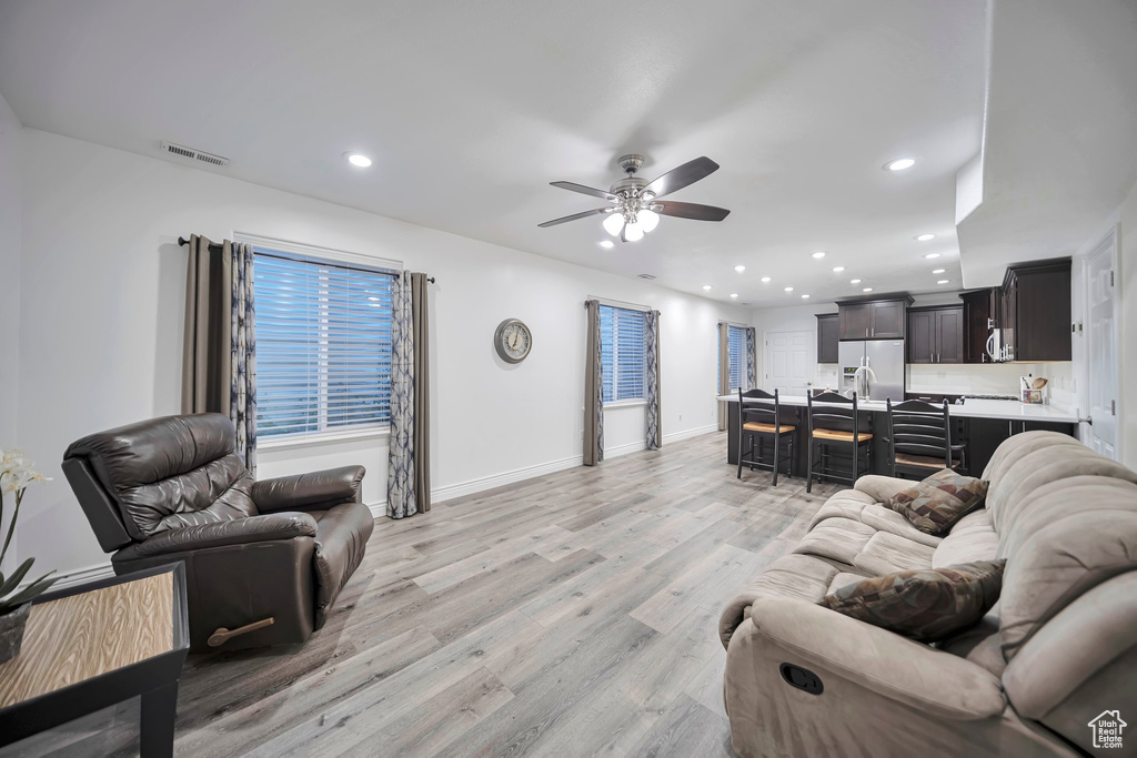 Living room featuring recessed lighting, light wood-style floors, ceiling fan, baseboards, and visible vents