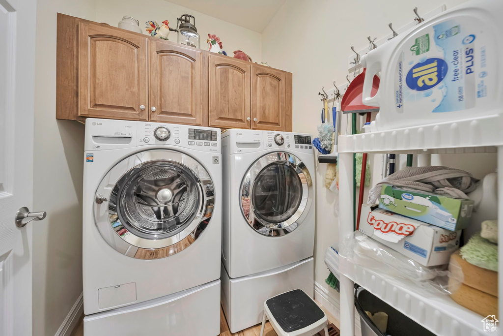 Laundry area with cabinet space and washing machine and clothes dryer