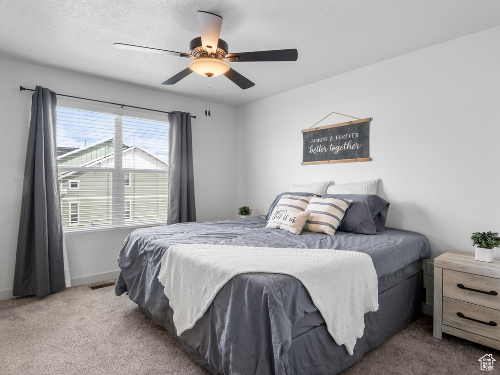 Bedroom featuring carpet floors, baseboards, ceiling fan, and visible vents