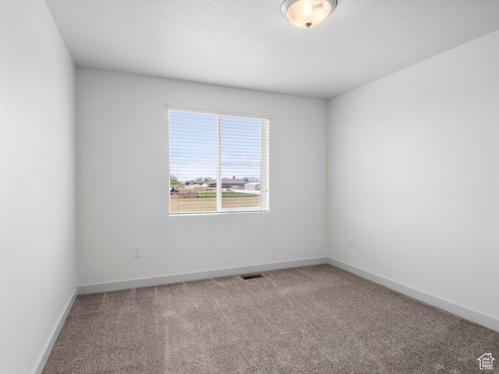 Empty room with carpet flooring and baseboards