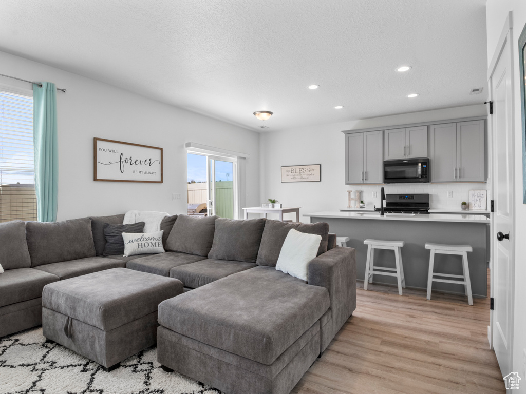 Living room with recessed lighting and light wood-style floors
