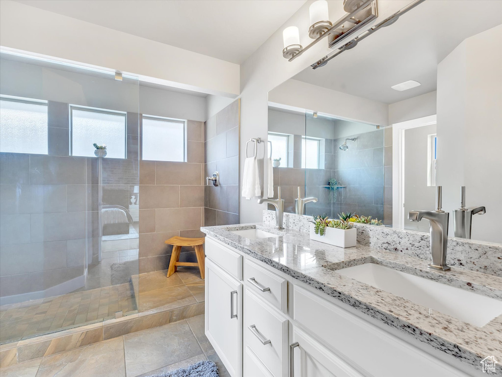 Bathroom with double vanity, a sink, and a walk in shower