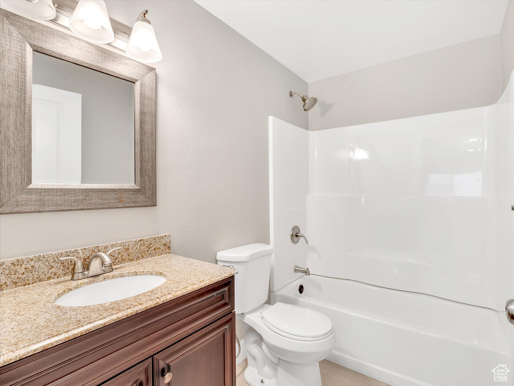 Bathroom featuring vanity, shower / bath combination, and toilet