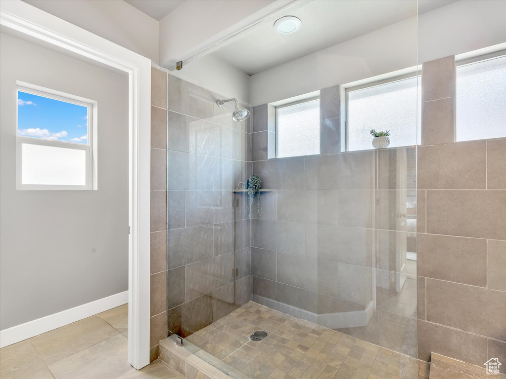 Bathroom with tile patterned floors, walk in shower, and baseboards