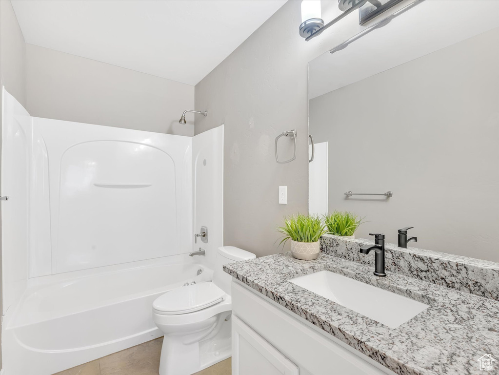 Full bath featuring toilet, tub / shower combination, tile patterned flooring, and vanity