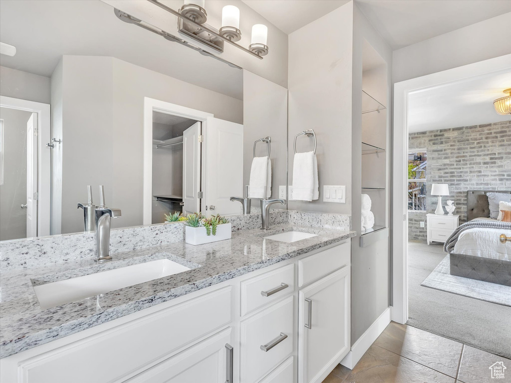 Full bathroom featuring double vanity, tile patterned floors, a sink, and ensuite bathroom