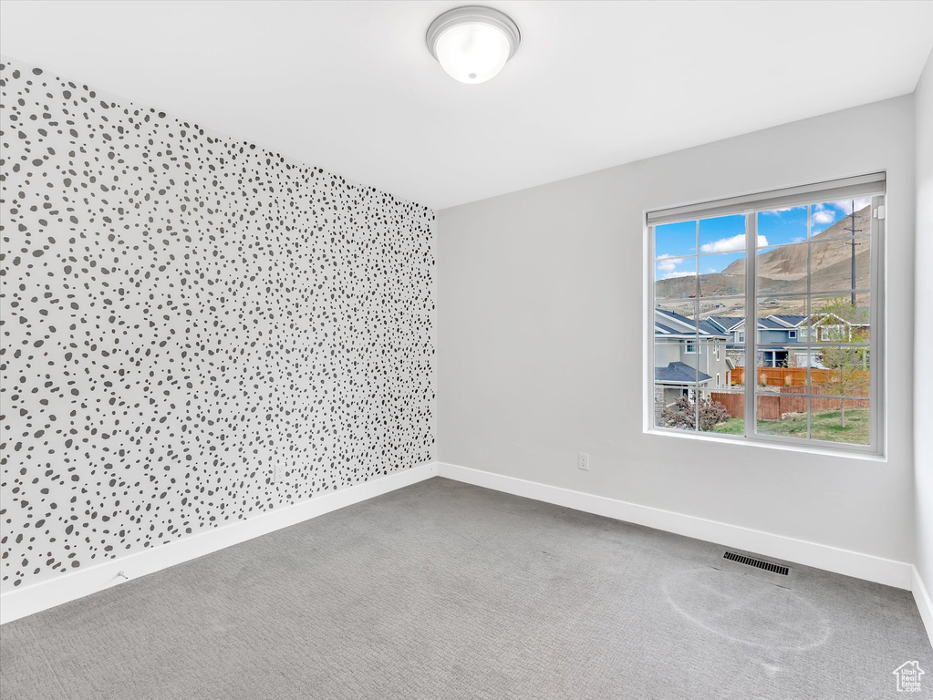 Spare room with baseboards, carpet flooring, and visible vents