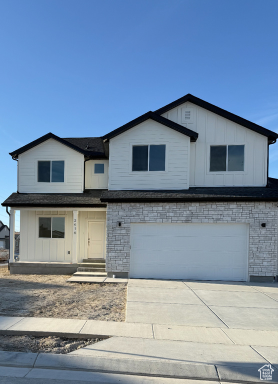 Traditional-style house featuring a garage, board and batten siding, and concrete driveway