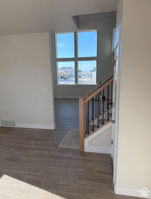Stairs featuring visible vents, baseboards, and wood finished floors