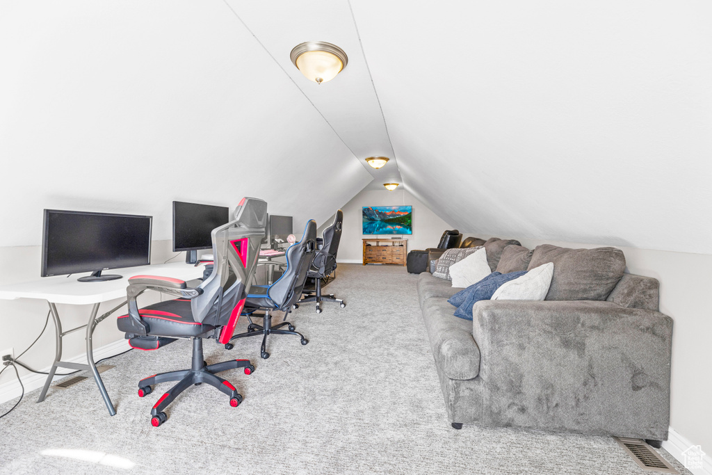 Office space with baseboards, carpet, and lofted ceiling