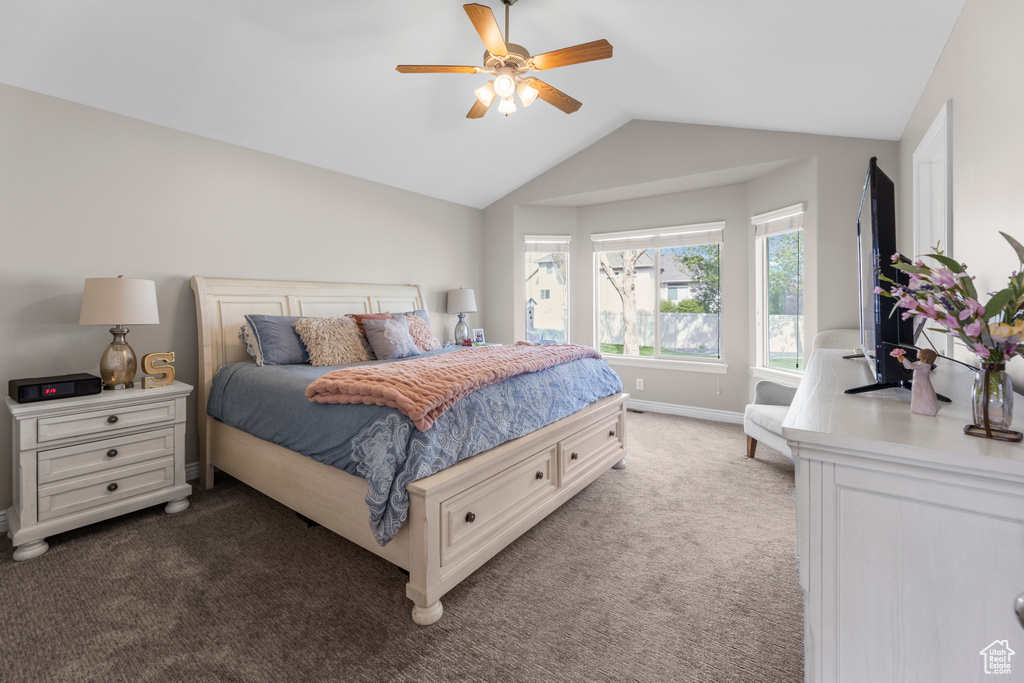 Carpeted bedroom with baseboards, ceiling fan, and vaulted ceiling