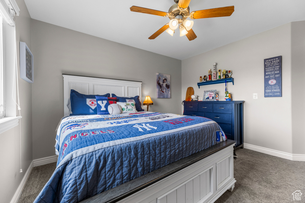 Carpeted bedroom featuring baseboards and ceiling fan