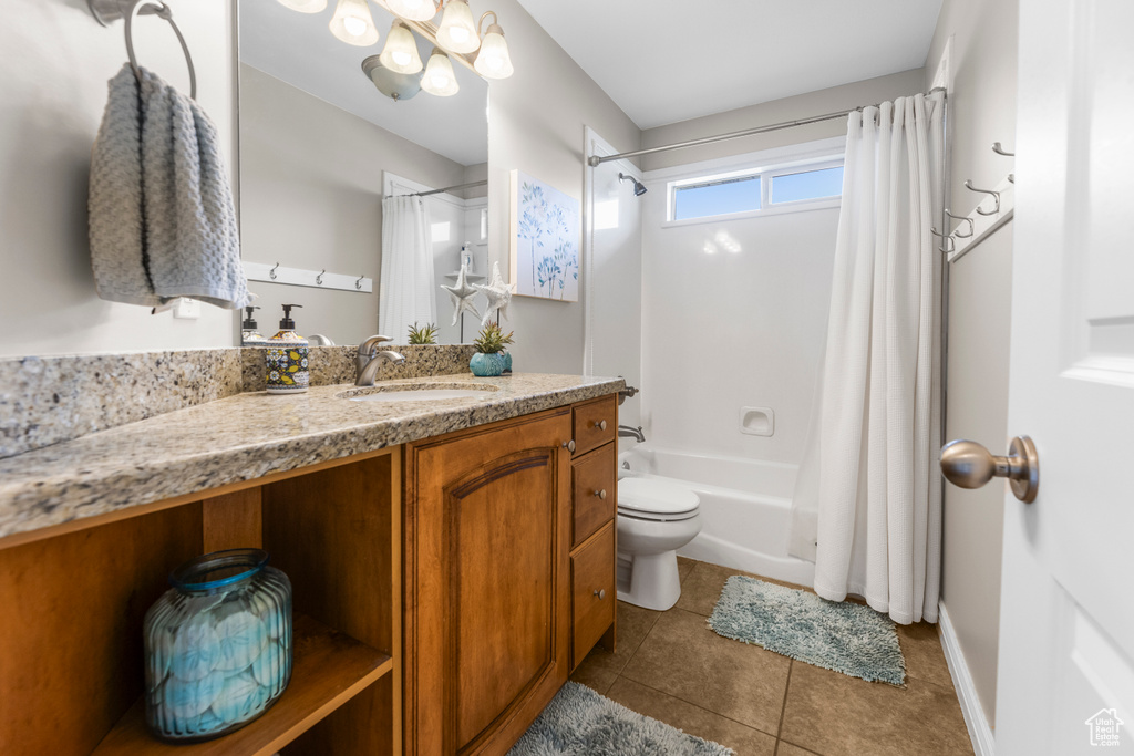 Full bathroom featuring tile patterned floors, baseboards, vanity, toilet, and shower / tub combo with curtain