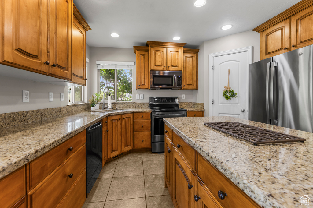 Kitchen featuring brown cabinetry, a sink, and appliances with stainless steel finishes