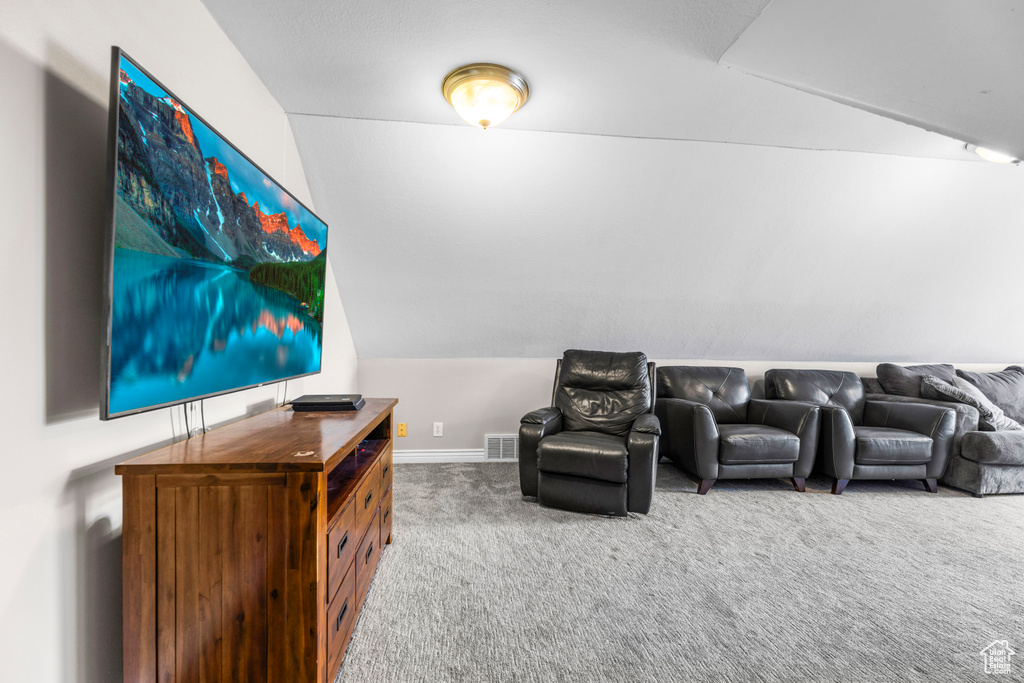 Cinema room featuring vaulted ceiling, visible vents, and carpet