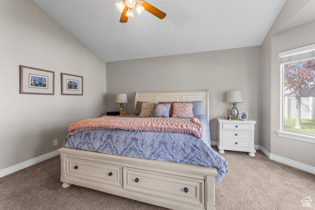 Bedroom featuring multiple windows, light carpet, and vaulted ceiling